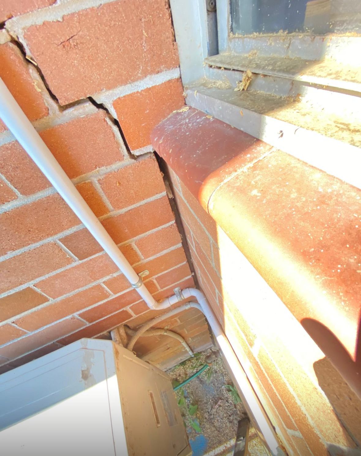 Stepped cracking in face brickwork next to a window sill